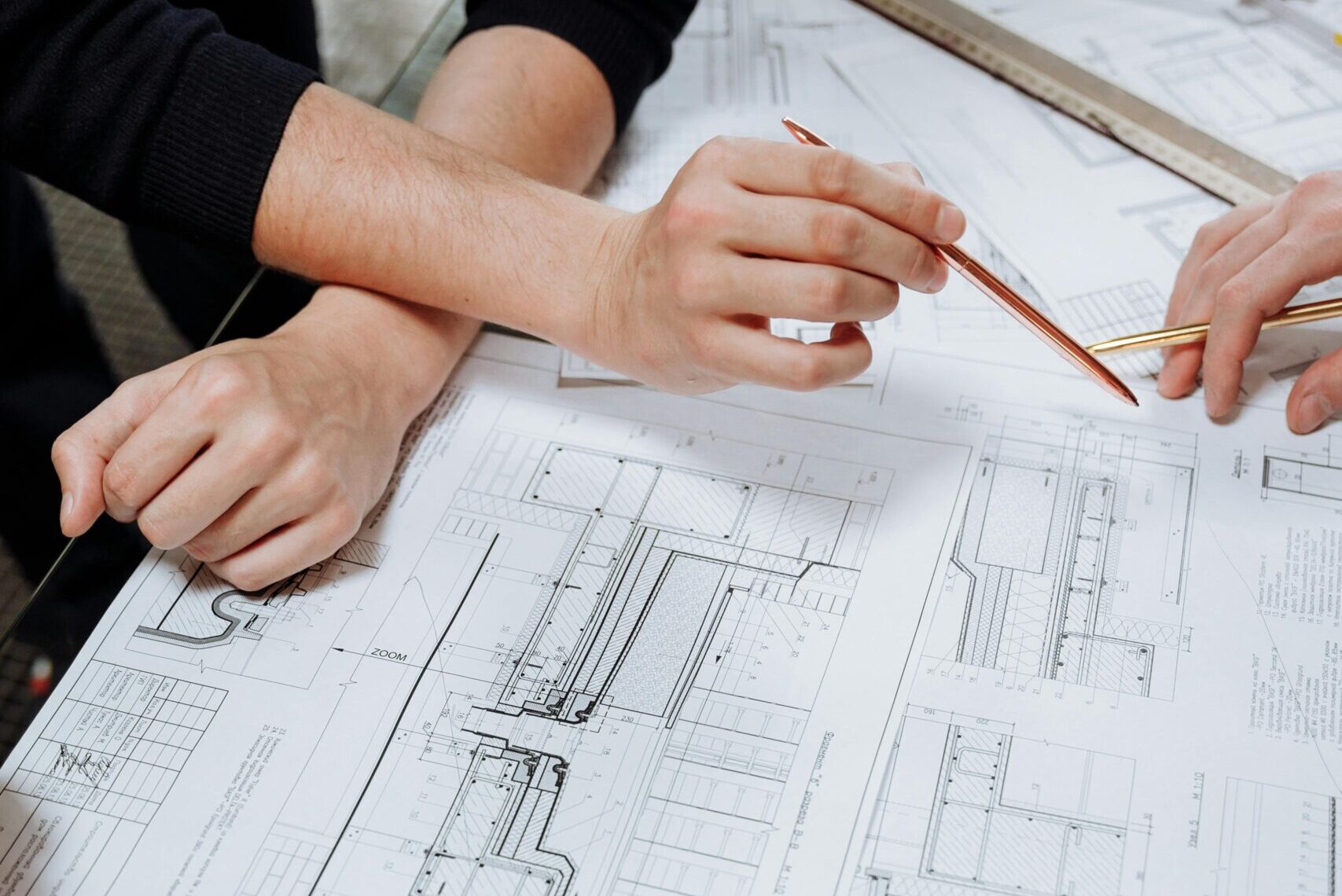 Architects discussing detailed blueprints and schematics at a table.